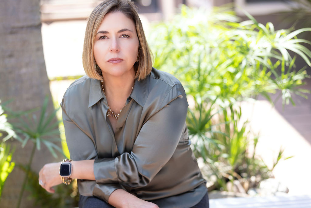 Ingrid Rainey, Managing Partner of Rainey Law P.C., photographed in a sunlit San Diego courtyard